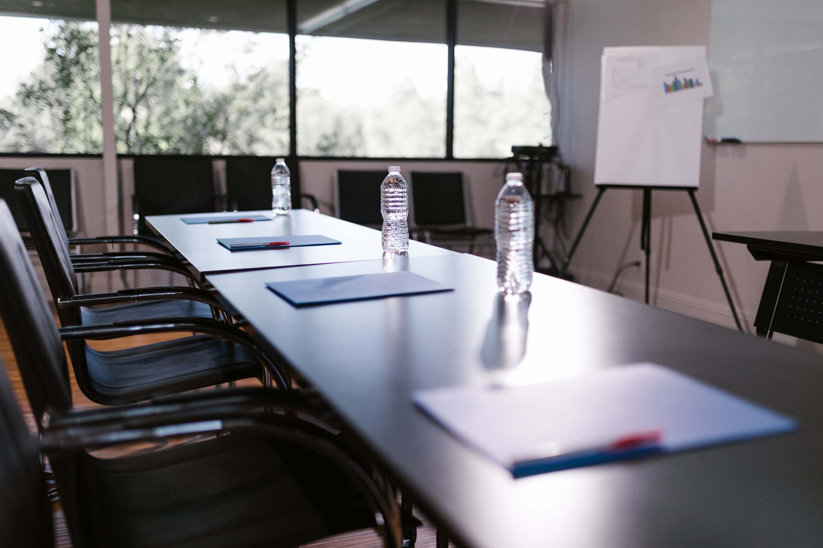 Conference room with water bottles and notes on a wooden table ready for a meeting