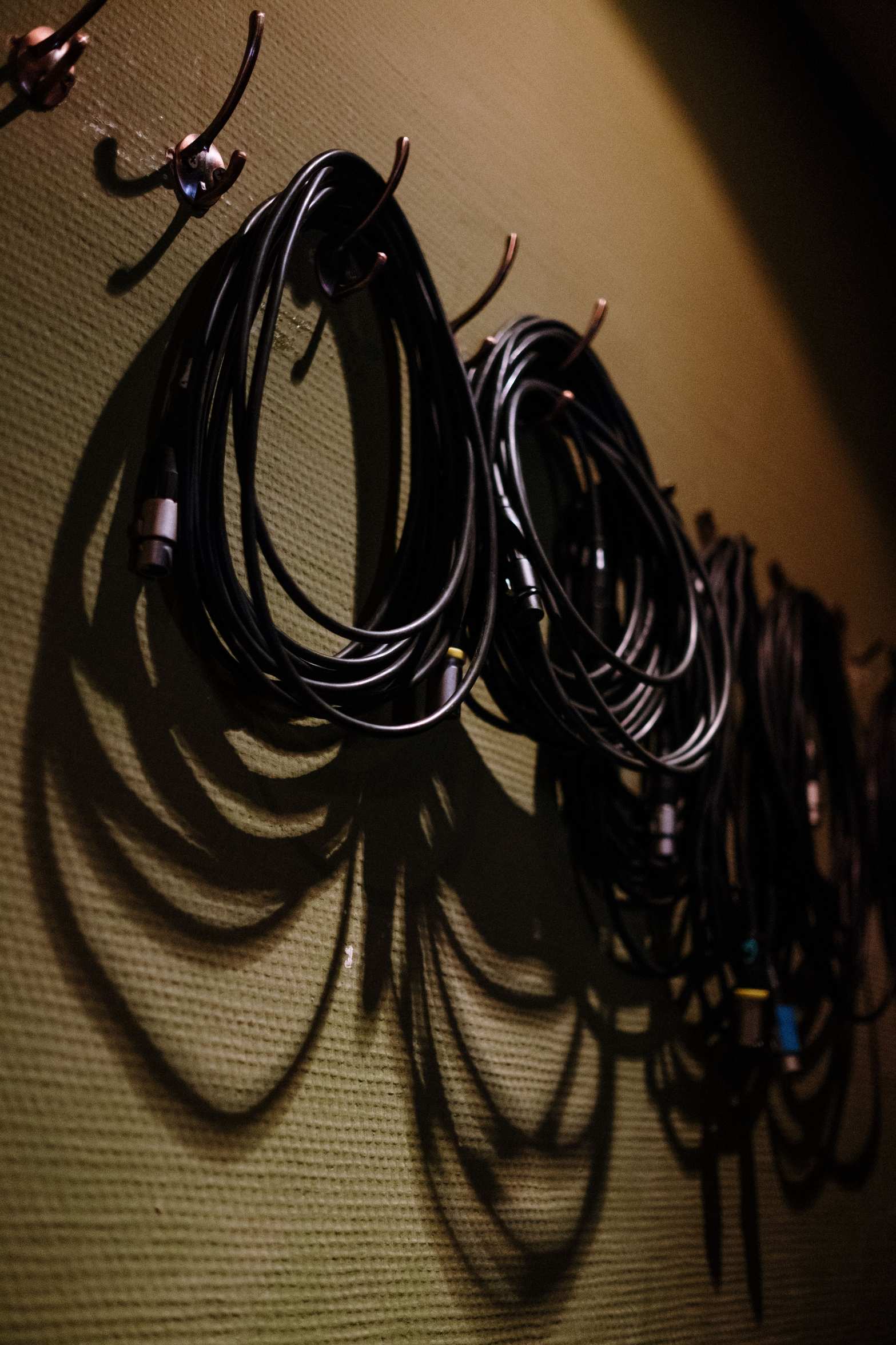 Server equipment with network cabling, coiled black cables hanging on hooks
